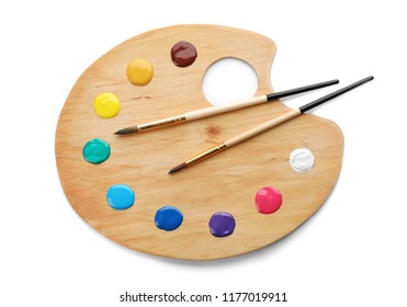 Palette with paints and brushes on white background, top view