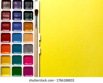 A Palette Of Watercolors And Paintbrushes On A Yellow Background With Space For Text. Children's Creativity, Creative Classes At Home And School, Art Master Class, The Concept Of Development. Flatlay