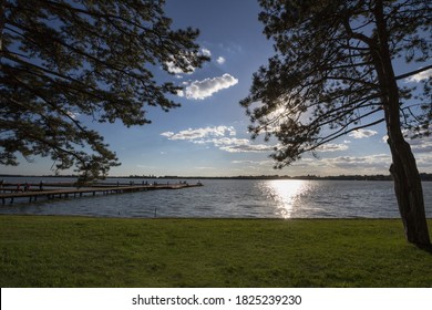 Palic Lake, in Subotica, Serbia, with pine trees and a green lawn in the background, during an autumn sunset. Also known as Palicko Jezero, it is one of the main attractions of Vojvodina province.

 - Shutterstock ID 1825239230