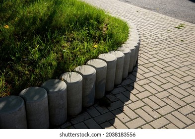 Palisade made of concrete of various shapes and profiles is widely used especially in garden architecture in solving smaller height differences, for edging raised flower beds, ornamental grassy areas. - Shutterstock ID 2038183556