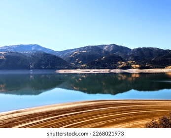 Palisades in ID, marks from the tide on the beach highlighted by mountain reflection  - Shutterstock ID 2268021973