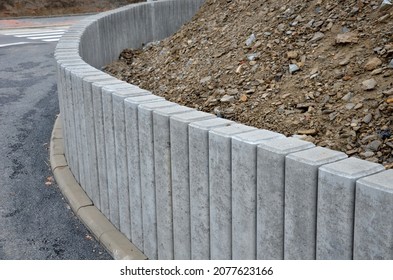 Palisades made of square-profile concrete with sloping staircase arches in garden architecture. solution of smaller terrain differences, support of slopes for edging raised flower beds on construction - Shutterstock ID 2077623166