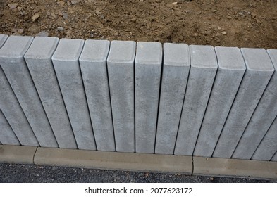 Palisades made of square-profile concrete with sloping staircase arches in garden architecture. solution of smaller terrain differences, support of slopes for edging raised flower beds on construction - Shutterstock ID 2077623172