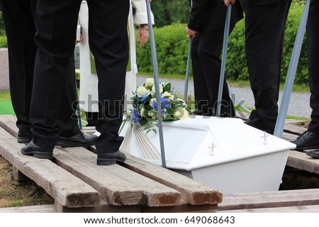 Pallbearers putting down the coffin at a funeral
