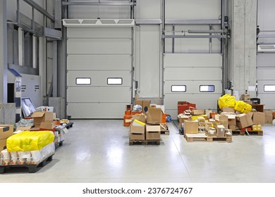 Pallets With Goods at Floor in Front of Loading Doors Distribution Warehouse Interior