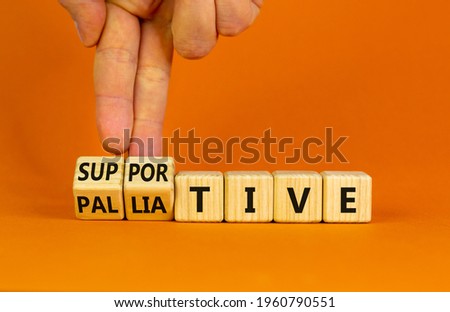 Palliative or supportive therapy symbol. Doctor turns cubes, changes words palliative to supportive. Beautiful orange background, copy space. Medical, palliative or supportive therapy concept. Stockfoto © 