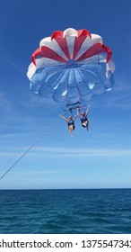 PALM BEACH, ARUBA - JAN 20TH, 2016: two girls having fun while doing parasailing in the caribbean, aruba.