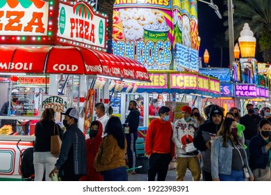 Palm Beach, Florida - USA - January 18, 2021 - The Midway At The State And County Fair With Junk Food Vendors, Amusement Park Games, Ferris Wheel, Carnival Rides And Families Enjoying The Festival