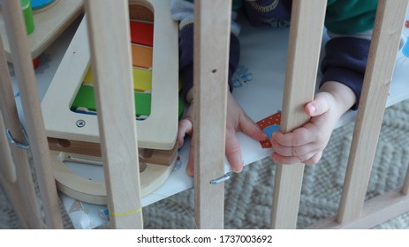 Palm hands of a little baby in a baby cot. Playing. Researching. Touching.