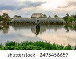 Palm house in Kew botanical gardens reflected in pond, London, UK