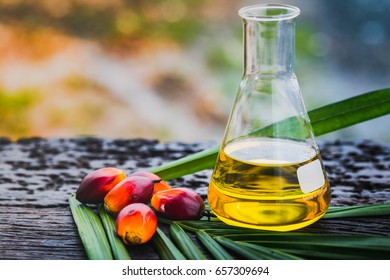 Palm Oil Bottle, Palm Fruit In Rattan Basket And Palm Leaf On Old Wood Floor