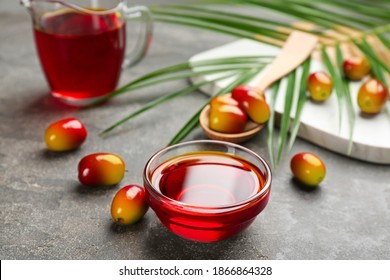 Palm Oil In Glass Bowl, Tropical Leaf And Fruits On Grey Table