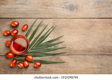 Palm Oil In Glass, Tropical Leaf And Fruits On Wooden Table, Flat Lay. Space For Text