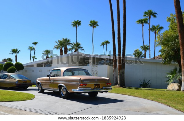 Palm Springs\
California USA 16 august 2017 Turn of century house with a golden\
vintage car in the drive\
way