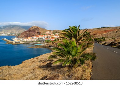 Palm Trees Mountain Road And View Of Traditional Village Houses And Port On East Coast Of Madeira Island, Portugal