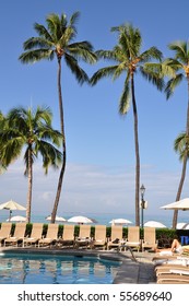 Palm trees and pool in front of ocean at  a famous historic hotel - on the island of Oahu along Waikiki beach built in 1901.