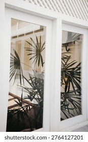 Palm trees visible through window frame