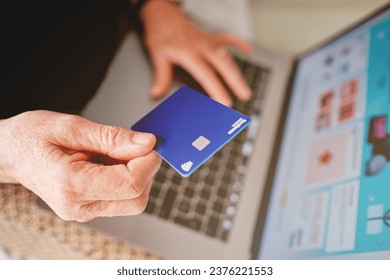 Palma, baleares, spain, november 20, 2020: adult woman holding a paypal card with her hand in front of the computer about to pay for a purchase