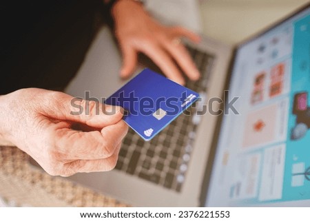 Palma, baleares, spain, november 20, 2020: adult woman holding a paypal card with her hand in front of the computer about to pay for a purchase