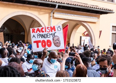 Palma de Mallorca, Spain - June 07 2020: Man surrounded by crowd holding a banner with the message about racism in a peaceful protest against racism and recent U.S. police brutality