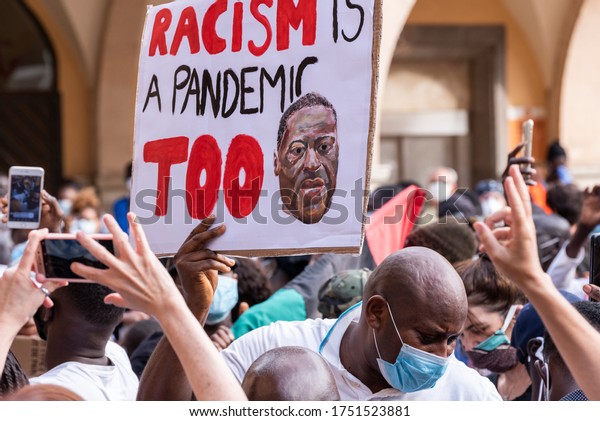 Palma de\
Mallorca, Spain - June 07 2020: Man surrounded by crowd holding a\
banner with the message about racism in a peaceful protest against\
racism and recent U.S. police\
brutality