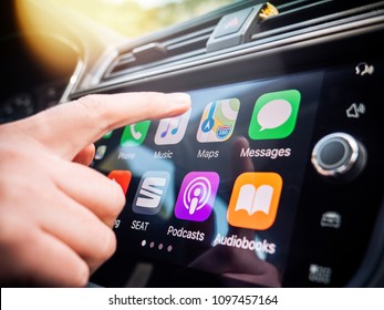 PALMA DE MALLORCA, SPAIN - MAY 10, 2018: Woman Pressing Apple Maps Button On The Apple CarPlay Main Screen In Modern Car Dashboard During Driving On Spanish Holiday Highway - Large Digital Display