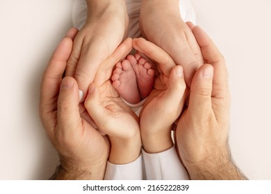 The palms of the father, the mother are holding the foot of the newborn baby. Feet of the newborn on the palms of the parents. Studio photography of a child's toes, heels and feet. Concept. - Shutterstock ID 2165222839