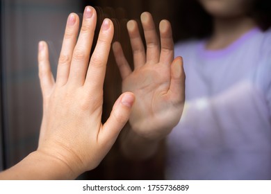 Palms Of A Woman And Child From Different Sides Of The Window