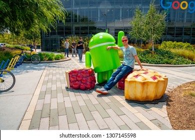 Palo Alto, USA. September 10, 2018. Young Man Sitting At The Google Office Near The Huge Android Sign In The Silicon Valley.