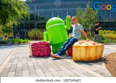 Palo Alto, USA. September 10, 2018. Young Man Sitting At The Google Office Near The Huge Android Sign In The Silicon Valley.