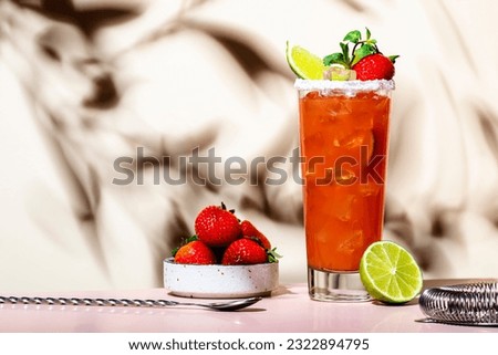 Paloma cocktail drink with silver tequila, grapefruit and lime juice, fresh strawberries, mint and ice in glass with salt rim. Beige pink background., copy space