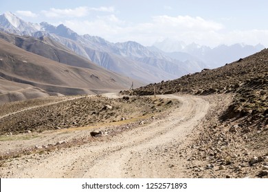 Pamir Highway In The Desert Landscape Of The Pamir Mountains In Tajikistan. Afghanistan Is On The Left