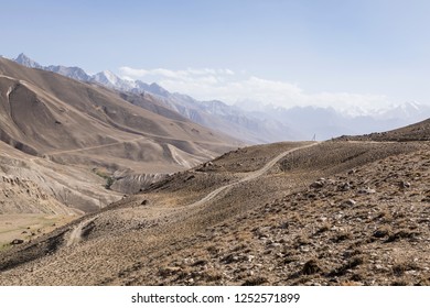 Pamir Highway In The Desert Landscape Of The Pamir Mountains In Tajikistan. Afghanistan Is On The Left