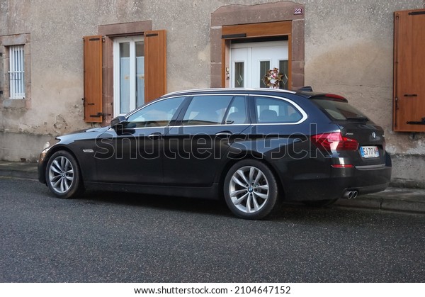 Pampelonne, France - Dec. 2021 - A black, 2013 BMW 3\
Series E91 Tourer parked on the street curbside, along a house : it\
is a luxury station wagon car produced by the German auto\
manufacturer BMW