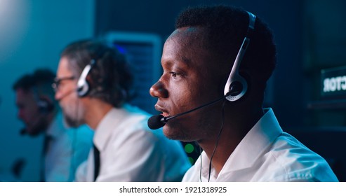 Pan around view of African American man with headset speaking during work in flight control center - Shutterstock ID 1921318925