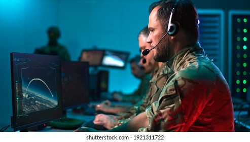 Pan Around View Of Bearded Military Man With Headset Giving Commands And Using Computer To Launch Nuclear Missile While Working In Control Center During World War.