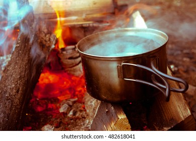 Pan Of Boiling Water On The Campfire. Touristic Campfire