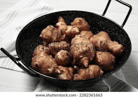 Pan with fresh Jerusalem artichokes on white wooden table, closeup [[stock_photo]] © 