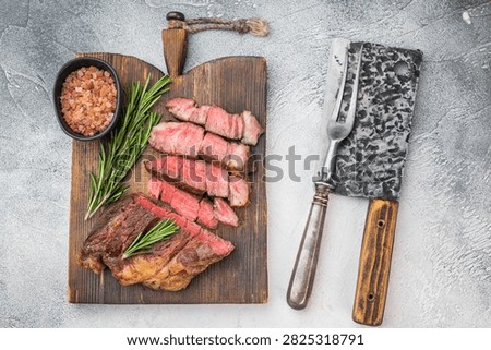 Pan fried Cooked beef chuckeye steak sliced and served with herbs and pink salt. Rustic beef dish with copy space top view