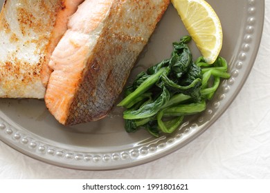 Pan Fried Hokkaido Salmon Fillet Served With Lemon And Spinach 