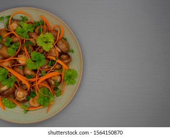 Pan Fried Mushrooms ,Fresh Shaved Carrot Salad Topped With Fresh Parsley On A Gray Background. Top View.