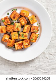 Pan fried paneer. Indian roasted cottage cheese bites on plate over light background. Top view, flat lay