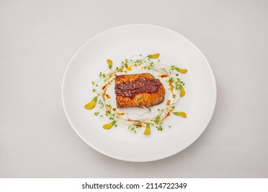 Pan Fried Salmon with Passion Fruit Sauce and sesban flower, isolated on white background, top view