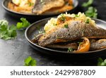 Pan fried sea bass fillets served with mashed potatoes and caramelised lemon