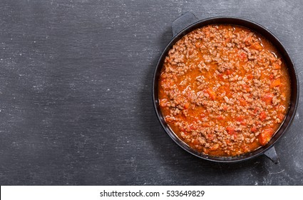 Pan Of Sauce Bolognese On Dark Background, Top View With Copy Space.