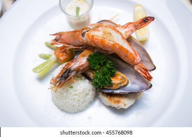 Pan Sear Sea Bass, Tiger Prawn, NZ Mussel, Garlic Rice With Market Vetetable And Cream Leek Sauce