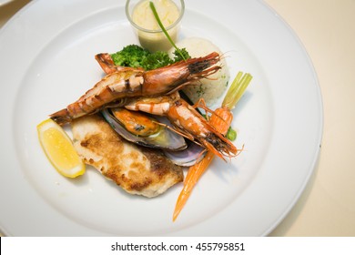 Pan Sear Sea Bass, Tiger Prawn, NZ Mussel, Garlic Rice With Market Vetetable And Cream Leek Sauce