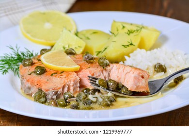 Pan seared salmon with lemon garlic caper butter sauce. Salmon piccata with rice and boiled potatoes.