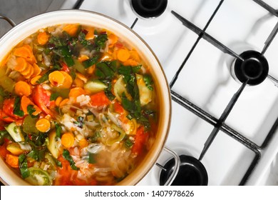 Pan Of Vegetable Soup On Gas Stove. View From Above