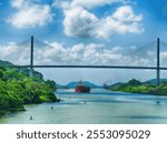 PANAMA CANAL - MAY 9, 2022 - Red cargo ship navigating the panama canal under the centennial bridge, a modern engineering marvel connecting north and south america